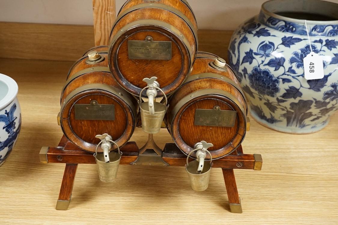 A set of three coopered oak and brass bound spirit barrels and stand, ivory mounted, early 20th century, 39cm wide. CITES Submission reference L87V7979